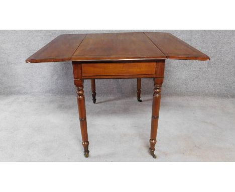 A 19th century mahogany drop flap Pembroke table on ring turned tapering supports terminating in brass cup casters. H.74 W.10