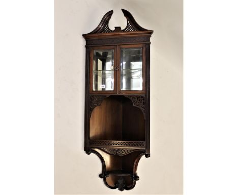 Good quality Edwardian mahogany hanging corner cabinet, the swan neck pediment above a blind fretwork frieze, two bevelled gl