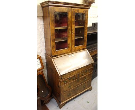 Walnut bureau bookcase, the moulded cornice above two shaped glazed panel doors enclosing shelves, the base with a fall front