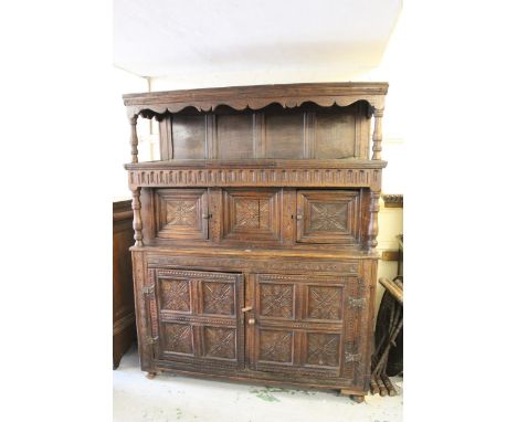 17th Century Welsh tridarn, the canopy top with a panelled back above two carved panelled doors, flanking a central carved pa