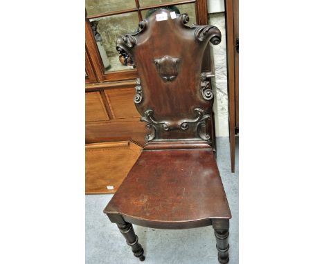 Victorian mahogany hall chair, the carved shield shaped back above a panel seat and turned tapering front supports 