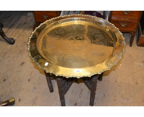 Two 19th Century Middle Eastern / Indian circular brass tray top occasional tables with folding stands, together with an orie