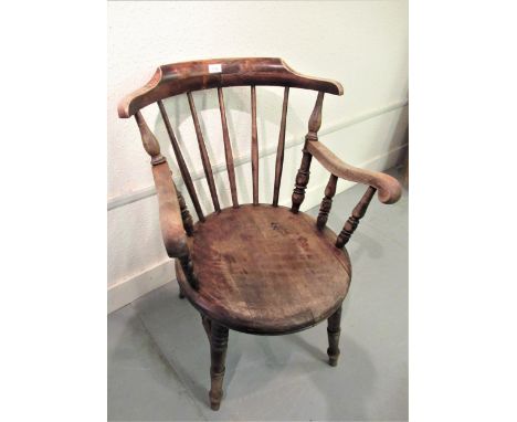 Early 20th Century beechwood spindle back elbow chair, the circular panel seat on turned supports 