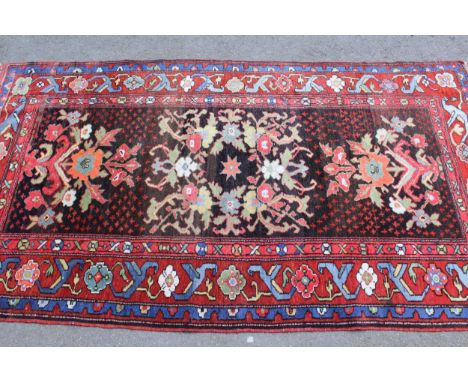 Anatolian rug with stylised floral design on a dark centre panel with polychrome borders, 7ft x 3ft 10ins approximately 