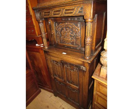 Small good quality reproduction oak side cabinet in antique style, the canopy top with carved panel door and turned fluted su