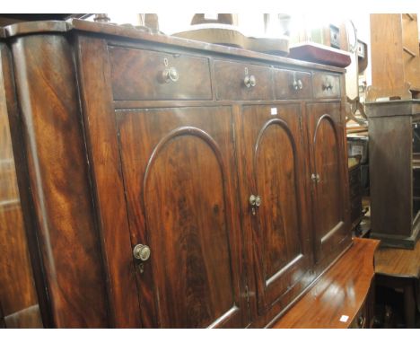 19th Century mahogany sideboard, the shallow figured top above four small frieze drawers and three arched panel doors with br