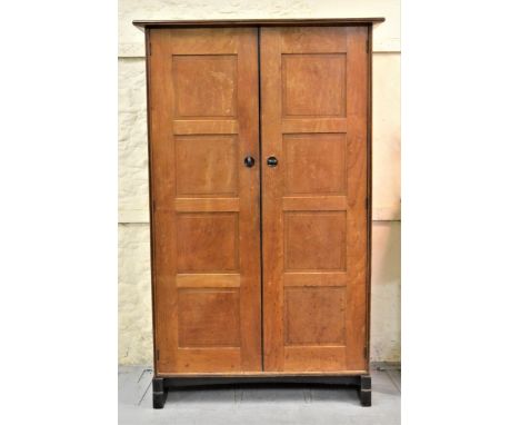 Attributed to Peter Waals (Cotswold school), cherry wood, black walnut and ebonised two door wardrobe, the moulded cornice ab