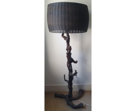 An antique oriental lamp with iron basketwork shade on rootwood base, 60" overall height.