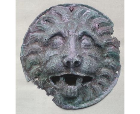 A Roman sheet bronze mount depicting a lion mask - possibly a phalera, 7.2" diameter.