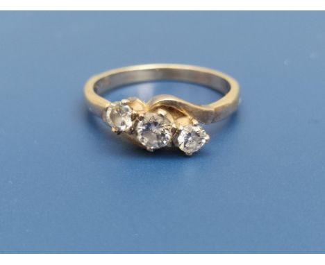 A three stone diamond crossover set ring, the central stone of approximately 4mm diameter, on '18ct' shank.  Finger size K.