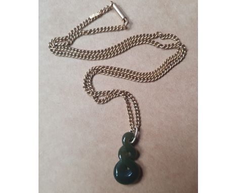 A Maori carved pounamu pendant on gold chain.