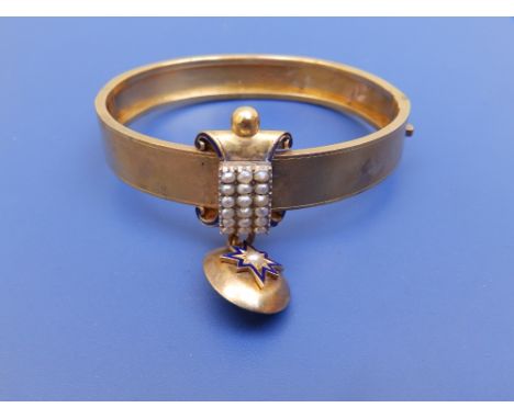 A Victorian gold bangle of plain Etruscan design, set with seed pearls and oval drop locket, dark blue enamel borders - tests