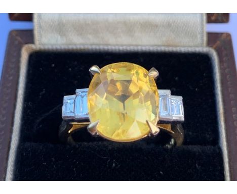 An art deco style certified natural 8.3 carat yellow Sri-Lankan sapphire &amp; diamond ring, the four-claw set oval mixed cut