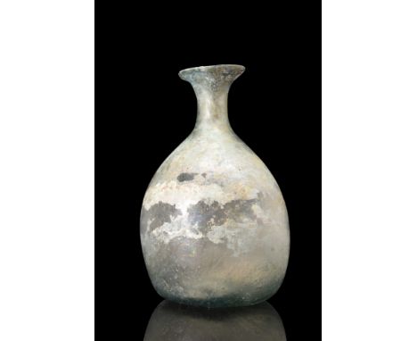 Ca. 100-300 AD.A glass flask features a distinctive bell-shaped lower body, a short tubular neck with a rounded rim, and a co