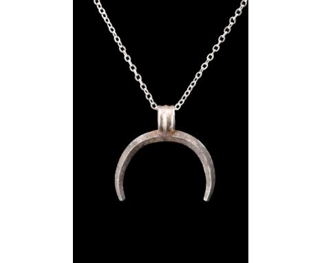 Ca. 100-300 AD.A silver pendant fashioned into the graceful form of a crescent. Impeccably crafted, the pendant exhibits dist