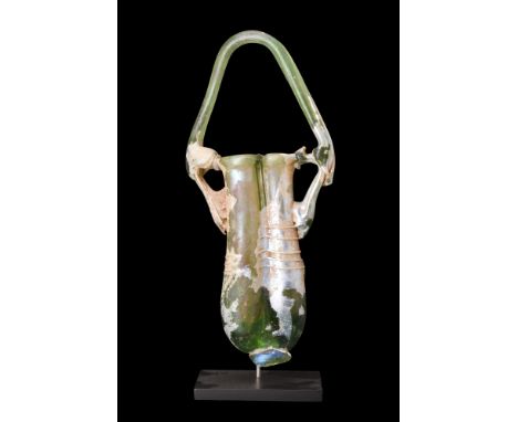 Ca. 1-200 AD.A double balsamarium crafted from pale green glass, displaying meticulous modeling and attention to detail. The 