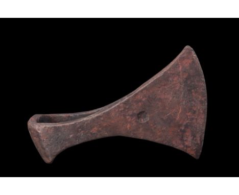 Ca. 900-1100 AD.An iron axe head distinguished by a broad, fan-shaped curved horizontal blade, this axe head showcases a desi