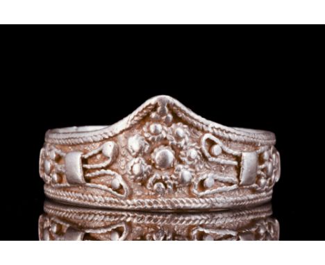 Ca. 500-700 AD.A silver finger ring of a flat section band that has been meticulously adorned with braided ropework borders, 