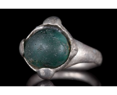 Northern European, ca. 1000-1200 AD.A silver ring comprising a lentoid-section hoop, flared shoulders, a discoid bezel with c