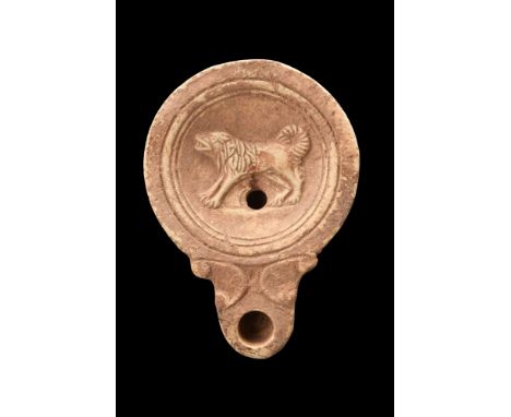 Ca. 100-300 AD.A terracotta oil lamp of the Loeschcke IV type featuring a round body and a recessed tondo adorned with the fi