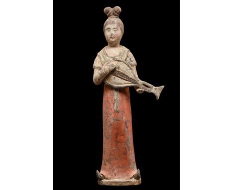 Ca. 618-907 AD.A mould-formed pottery tomb attendant figure represents a woman adorned in a traditional attire that epitomize