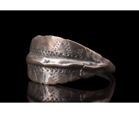 Ca. 900-1100 AD.A silver ring with its thin flat-section shank and a large and broad bezel, which is the focal point of the d