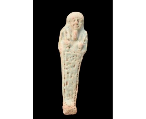 Late Period, Ca. 664-332 BC.Crafted from light faience, the ushabti with a mummiform style, stands atop a diminutive and leve