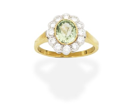 GREEN SAPPHIRE AND DIAMOND CLUSTER RINGThe oval-cut green sapphire set within a brilliant-cut diamond surround, mounted in 18