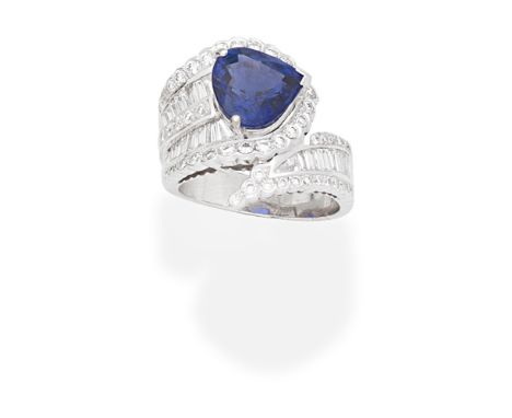 SAPPHIRE AND DIAMOND DRESS RINGOf cross-over design, set with a pear-shaped sapphire within a surround of brilliant and bague