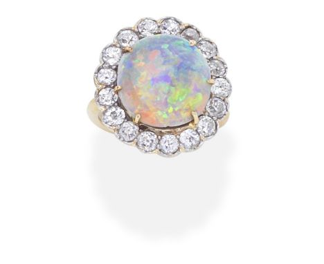 OPAL AND DIAMOND CLUSTER RINGThe circular opal cabochon within a cushion-shaped diamond surround, within closed back settings