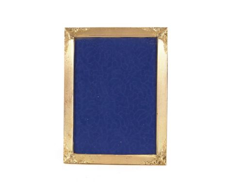 A silver photograph frame with engine turned decoration and foliate chased borders, 21cm x 15.5cm overall 
