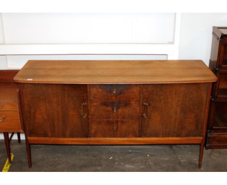 A teak sideboard fitted three central drawers, flanked by deep cupboards, raised on square section supports, 158cm wide x 50c