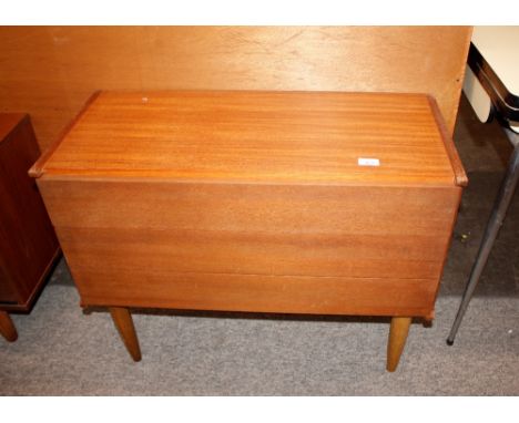 A teak G-plan design chest of three long drawers, raised on rounded tapering supports, 81cm wide 