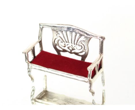 A pin cushion in the form of a miniature silver sofa