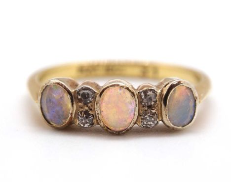 An opal and diamond ring, the three oval opal cabochons interspaced with two small single diamonds to each side, with plain b