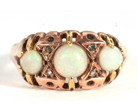 A three stone opal ring, the three graduated round opals interspaced with diamond highlights, all claw mounted with tapered s