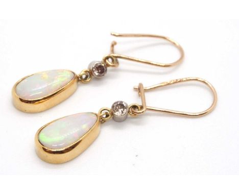 A pair of opal and diamond earrings, the pear shpae opal cabochon drops, collet mounted beneath a single cut diamond, 20mm lo