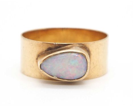 An opal ring, the pear shape opal cabochon, collet mounted to a plain band, 7.5mm wide, stamped 9ct, size M, 2.6g