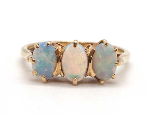 A 9ct opal ring, the three oval claw mounted opal cabochons, with plain band hallmarked Sheffield 1984, size L, 2.0g
