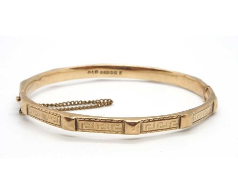 A 9ct gold bangle, the 5.5mm wide bangle with Greek key decoration and square bead detail, with integrated clasp and safety c