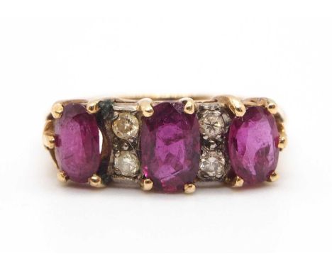 A ruby and diamond ring, the three oval rubies, interspaced with small round diamond highlights, with split tapered shoulders