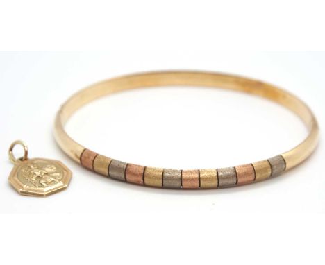 A tri-colour bangle and a pendant, the upper half of the hinged bangle set with textured bands of rose, yellow and white gold