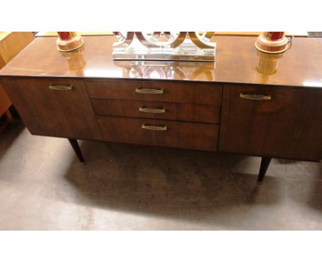 A 1960's faux mahogany sideboard, fitted three central drawers flanked by cupboards, raised on turned tapering supports, 171c
