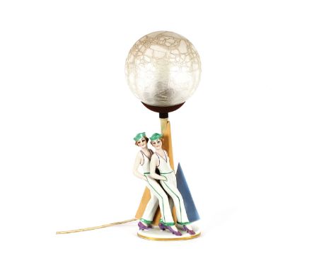 An Art Deco design porcelain table lamp, in the form of two sailor girls, having frosted glass globular shade