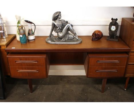 A teak G plan kneehole dressing table, fitted four drawers and raised on square section supports, 103cm wide