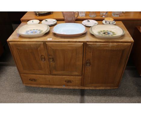 A light Ercol sideboard, fitted cupboards and single drawer, 113cm wide 