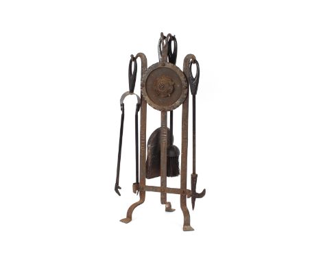 An iron companion stand with rose decoration and associated fire tools  
