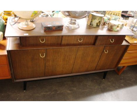 A teak G-plan sideboard fitted three drawers and cupboards under raised on ebonised tapering supports, drawers stamped E.G. G