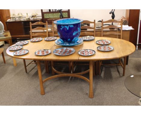 A light Ercol extending dining table raised on rounded tapering legs united by curved cross stretchers, 108cm x 210cm  extend