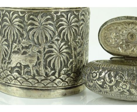 An Indian silver toilet jar and cover, embossed animal decoration, and an Eastern white metal oval snuff box (2)